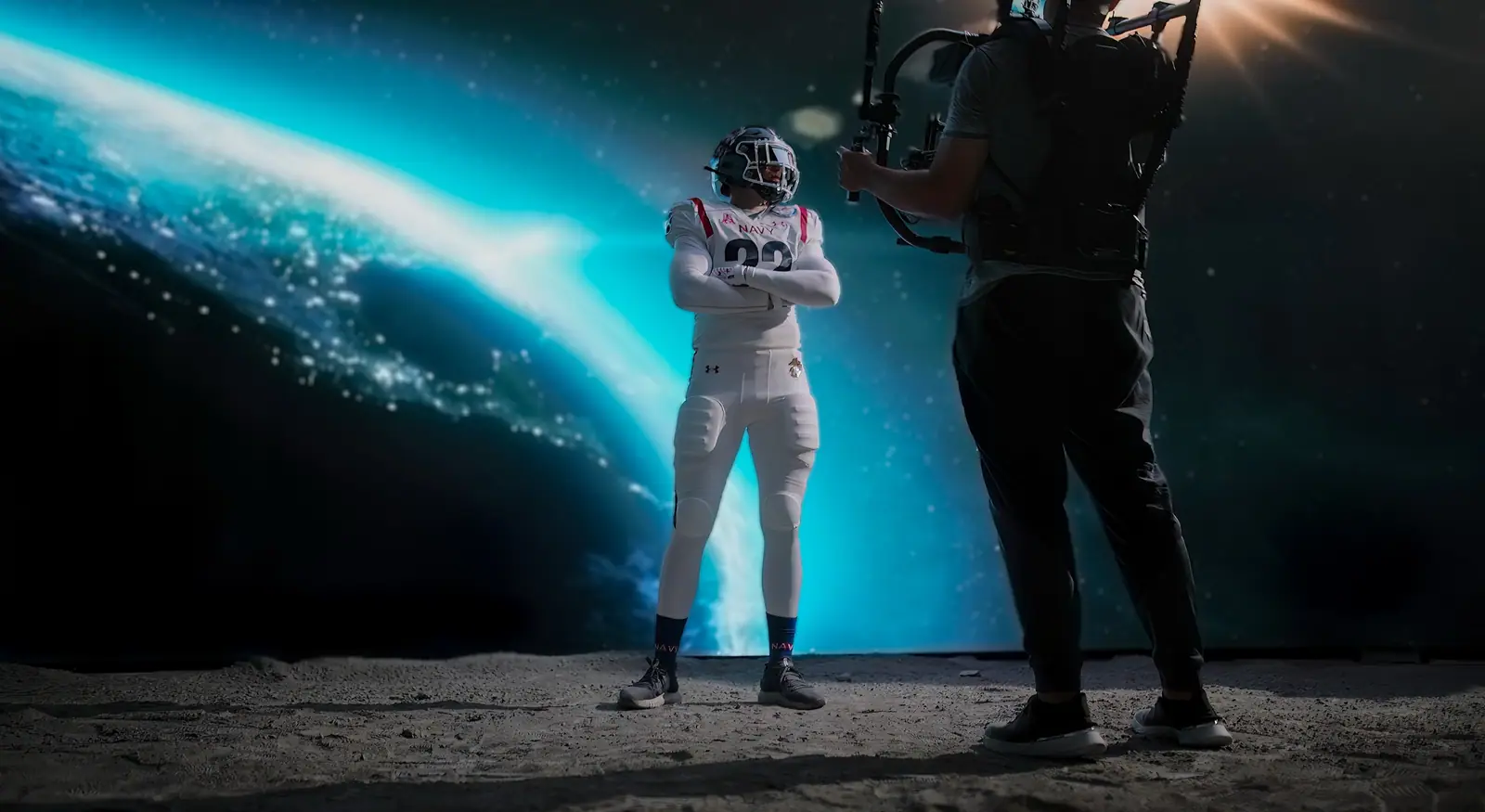 A Navy football player on a lunar set with Earth on the LED wall, Steadicam alongside