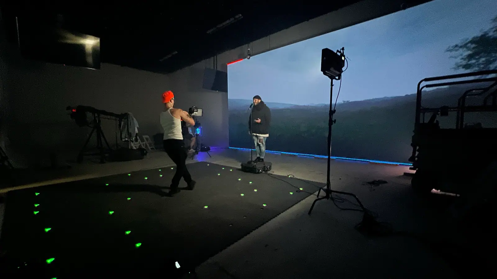 Performers on an LED volume stage under a moonlit mountain backdrop