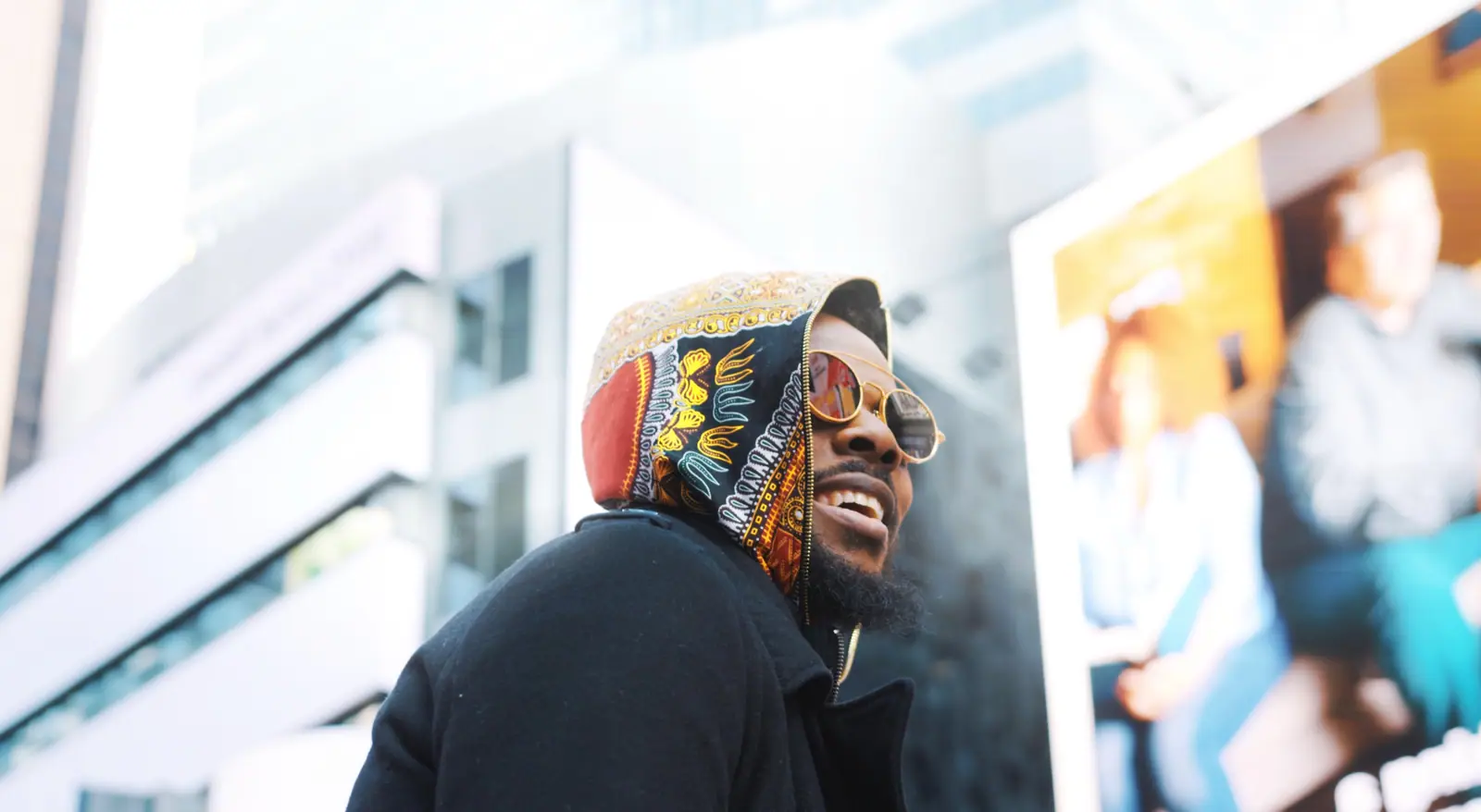 A street portrait: a smiling subject in a patterned hood