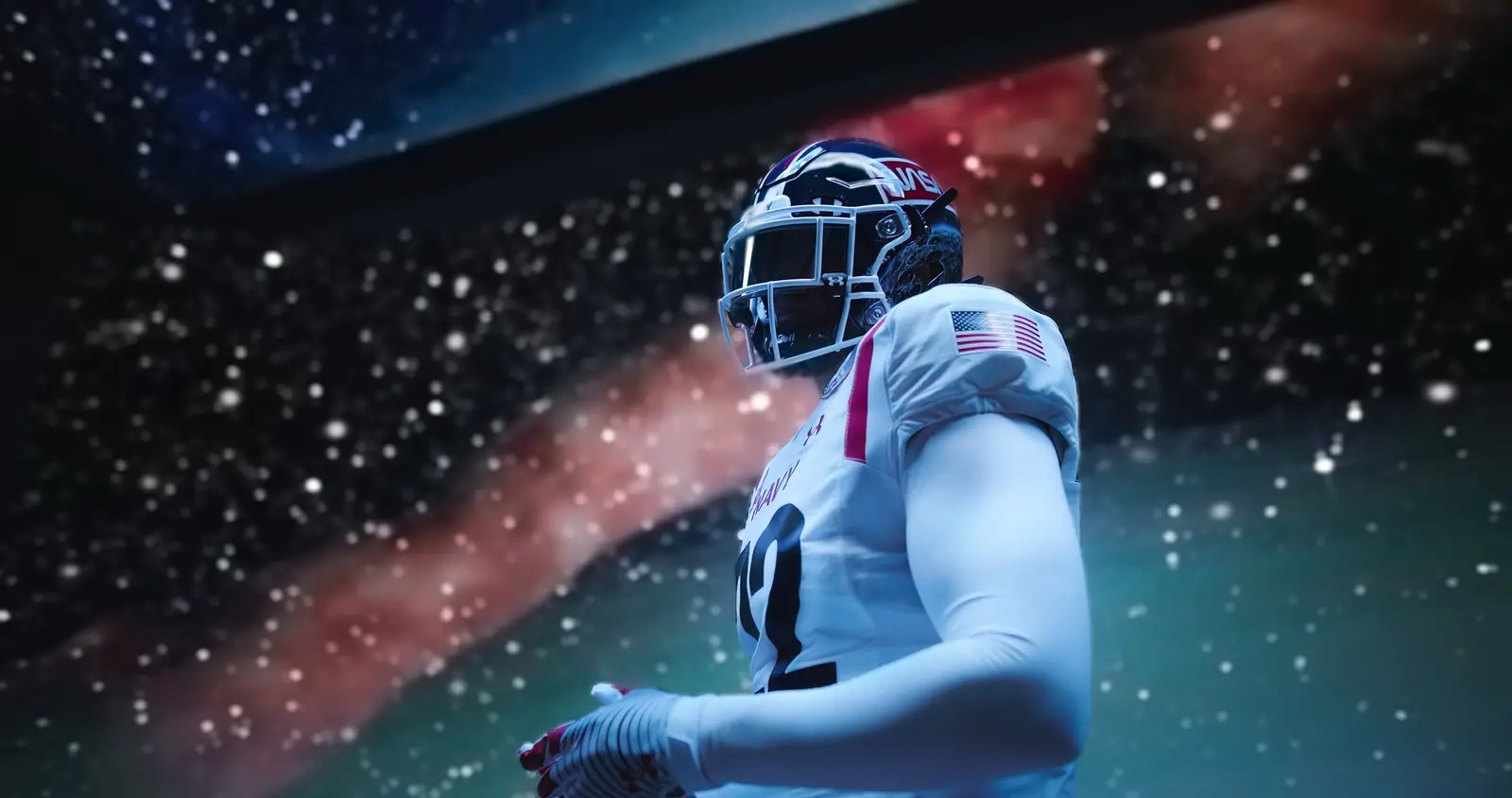 Low angle on a Navy football player against a starfield on the LED wall