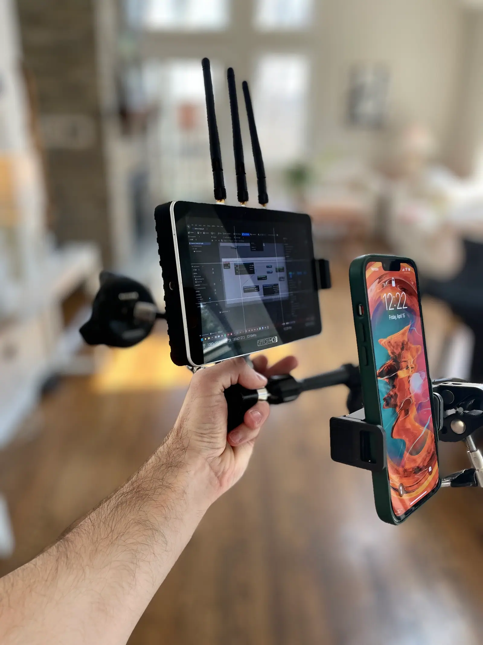 A wireless monitor and a phone rigged to a handheld grip