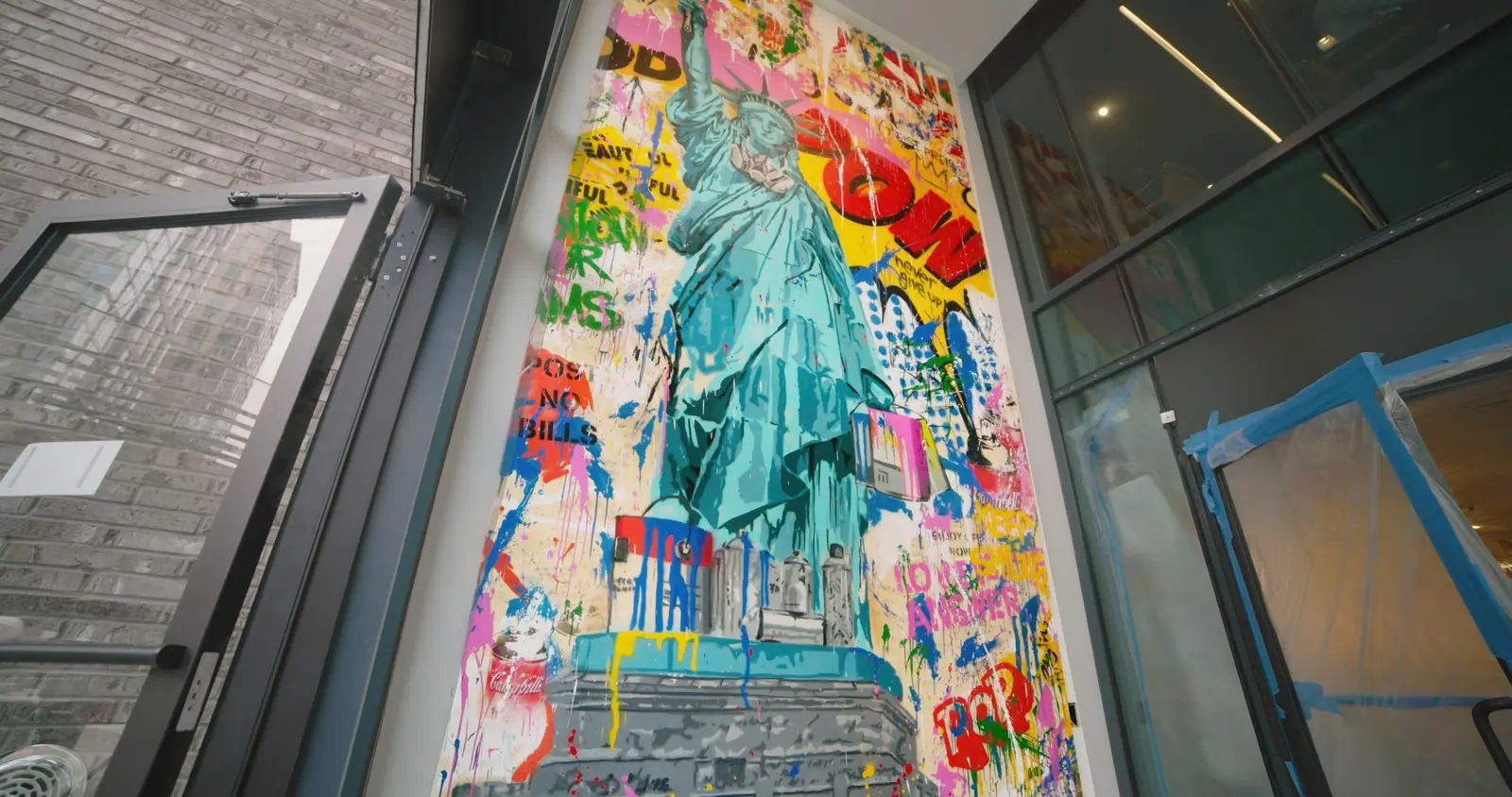 A tall Statue of Liberty panel, “never give up”, at the lobby entrance