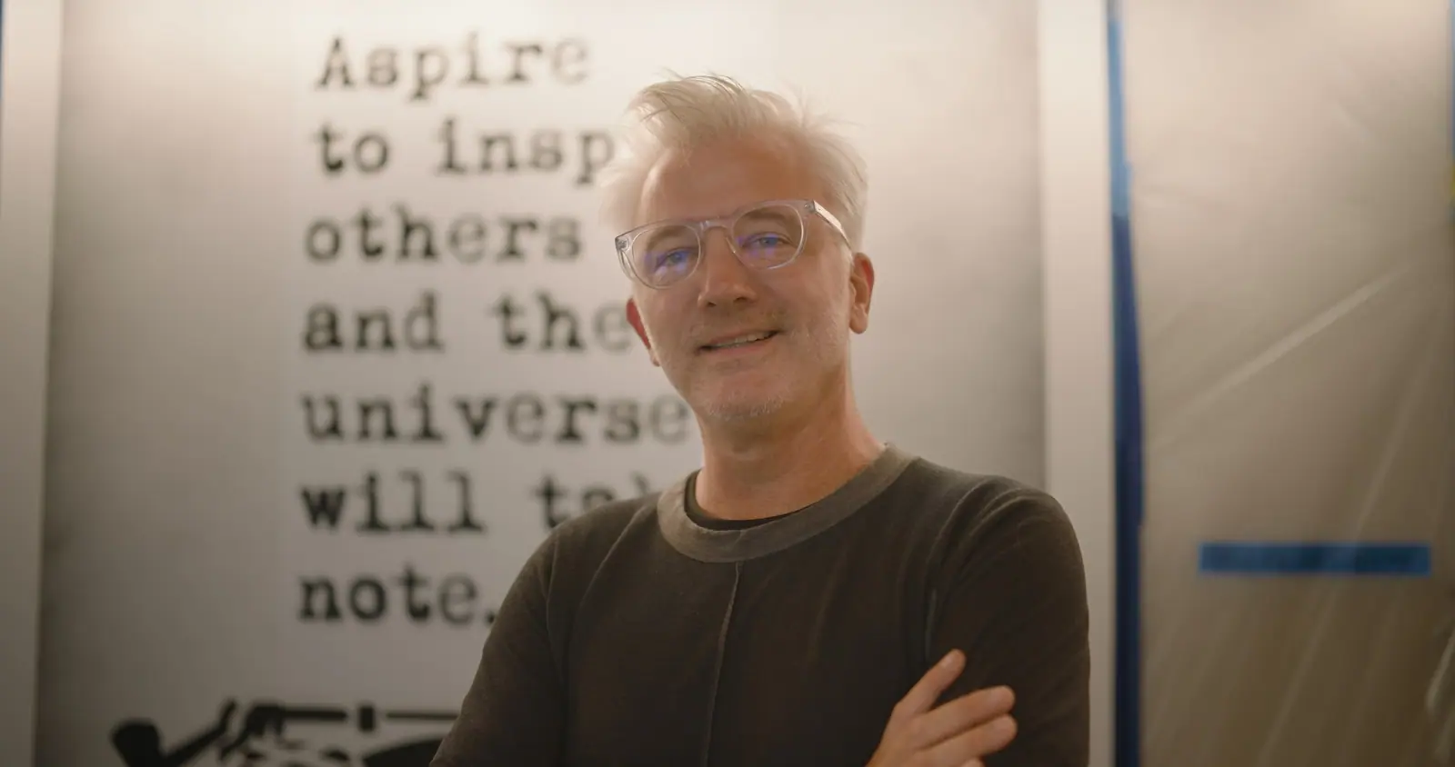 WRDSMTH in front of his “Aspire to inspire” piece