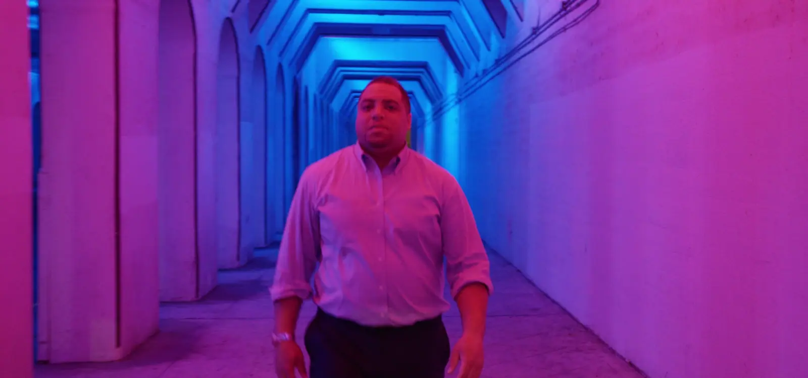 The firm's attorney in an underpass lit pink and blue