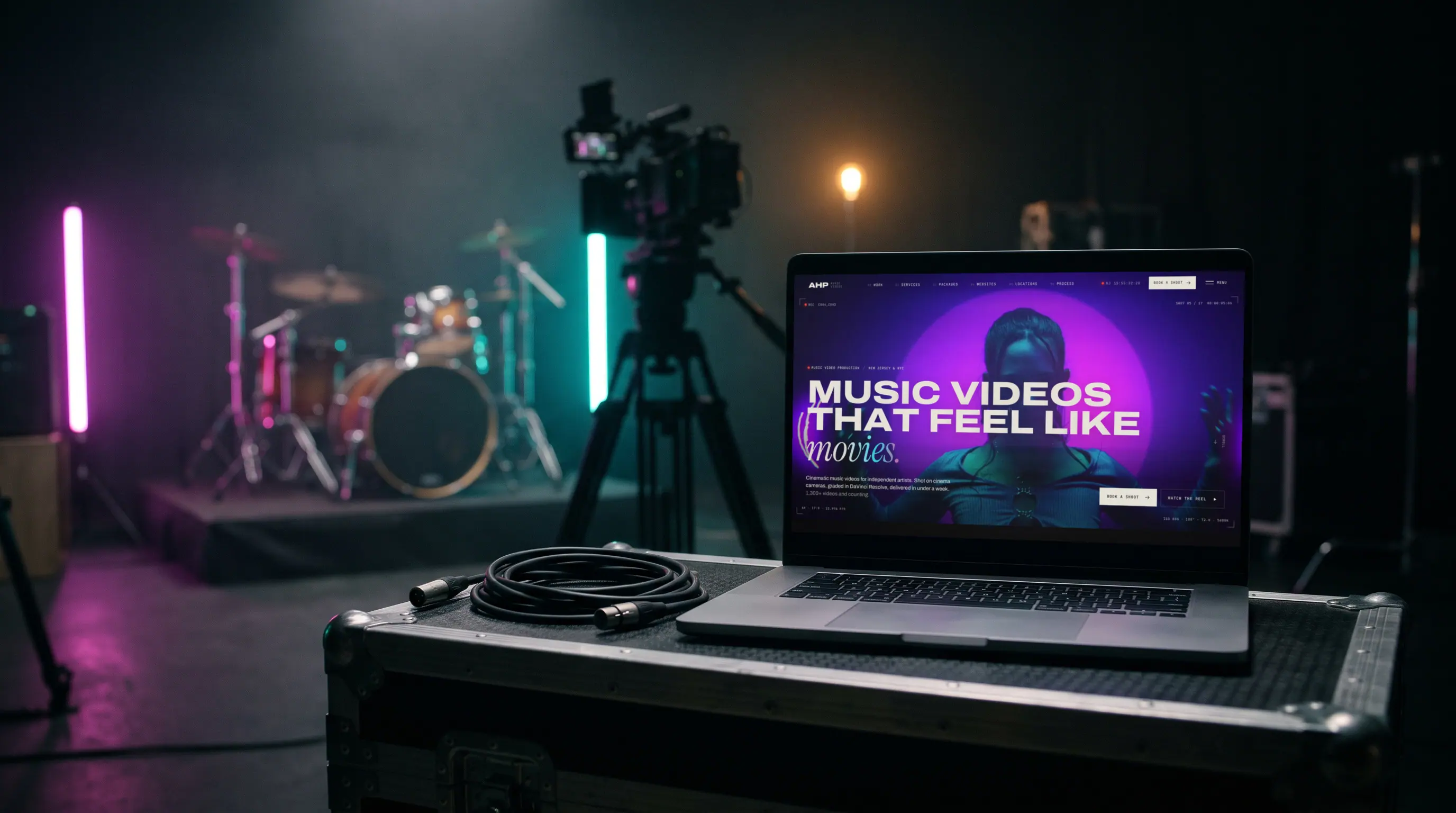 A laptop on a road case on a music video set, showing the AHP Music Videos website